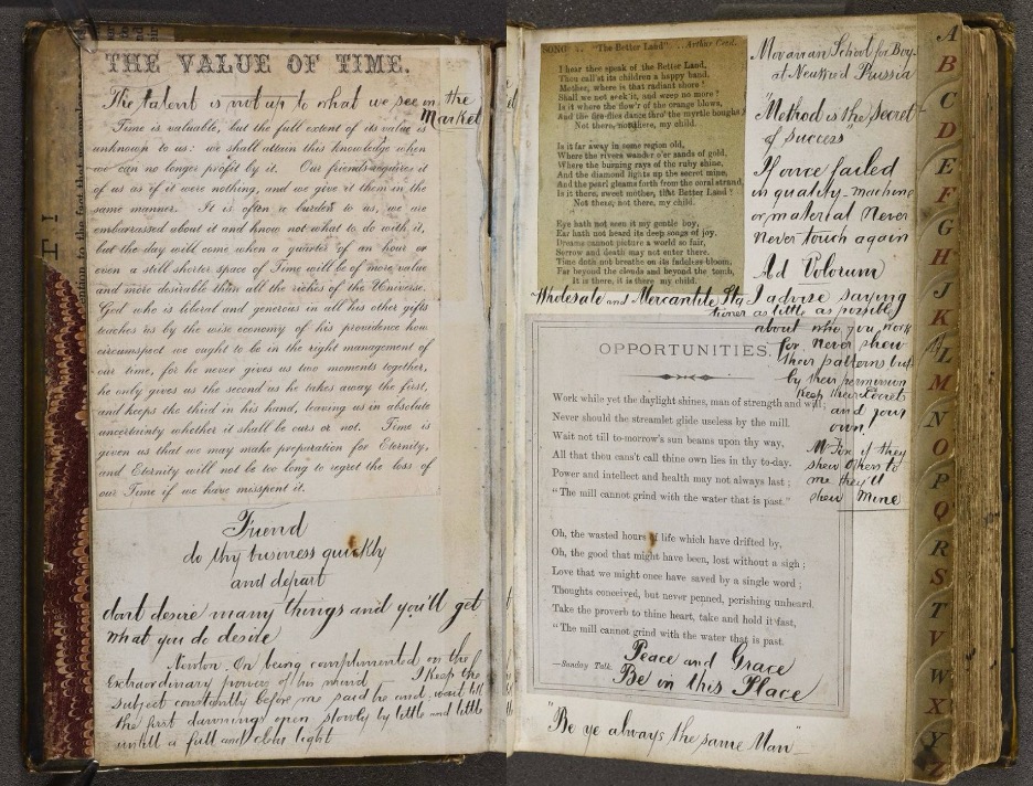 An open vintage scrapbook displays handwritten poems, motivational quotes, and pasted printed clippings 