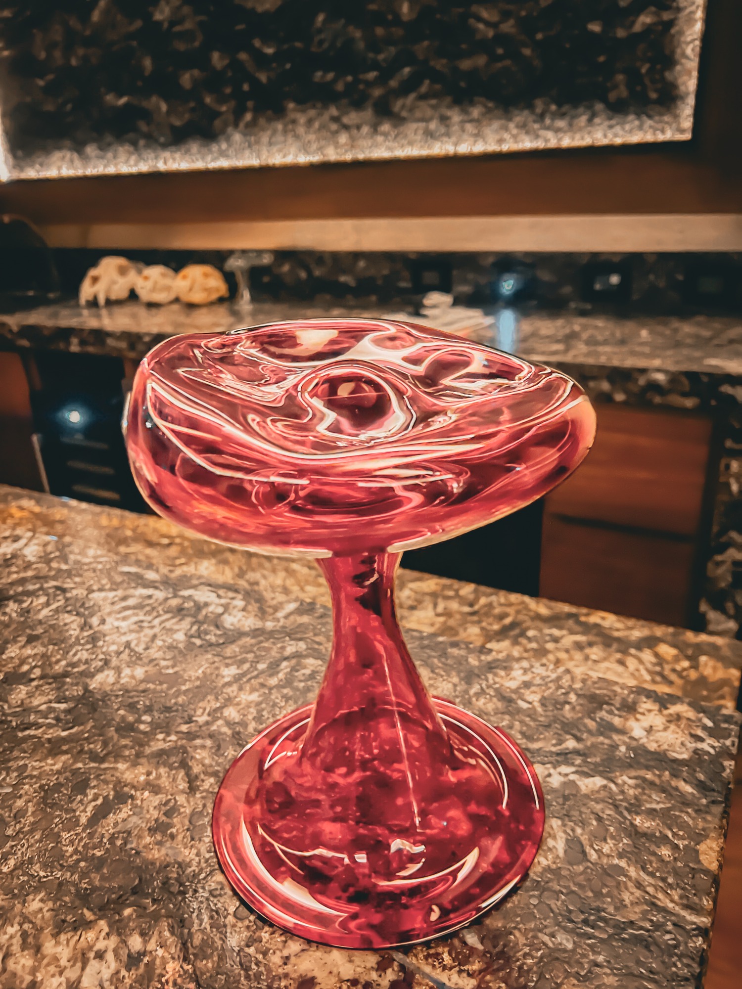 Ruby-colored glass Corner Enhancer with an elevated dish and tall base.