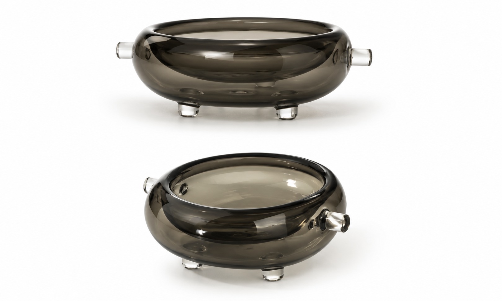 Two views of a dark glass Origins bowl with side handles and small feet.