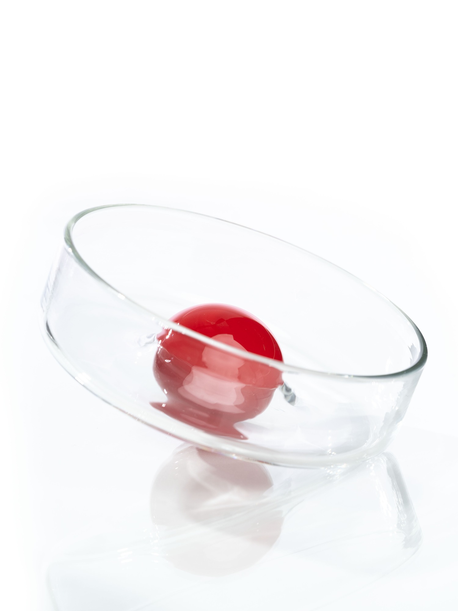 Clear glass Rowl Bowl with a red object inside.