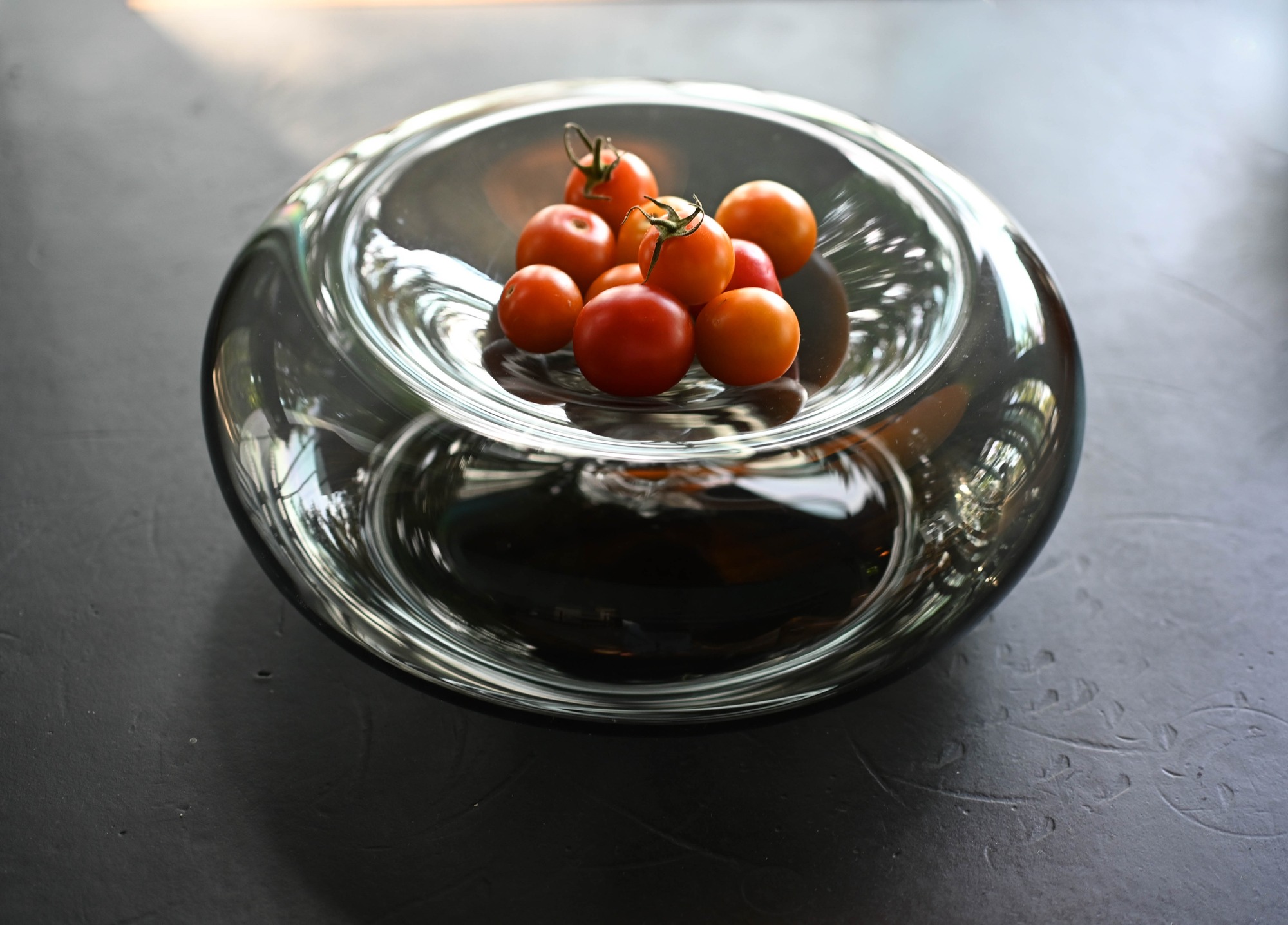 Shallow glass vessel holding tomatoes.