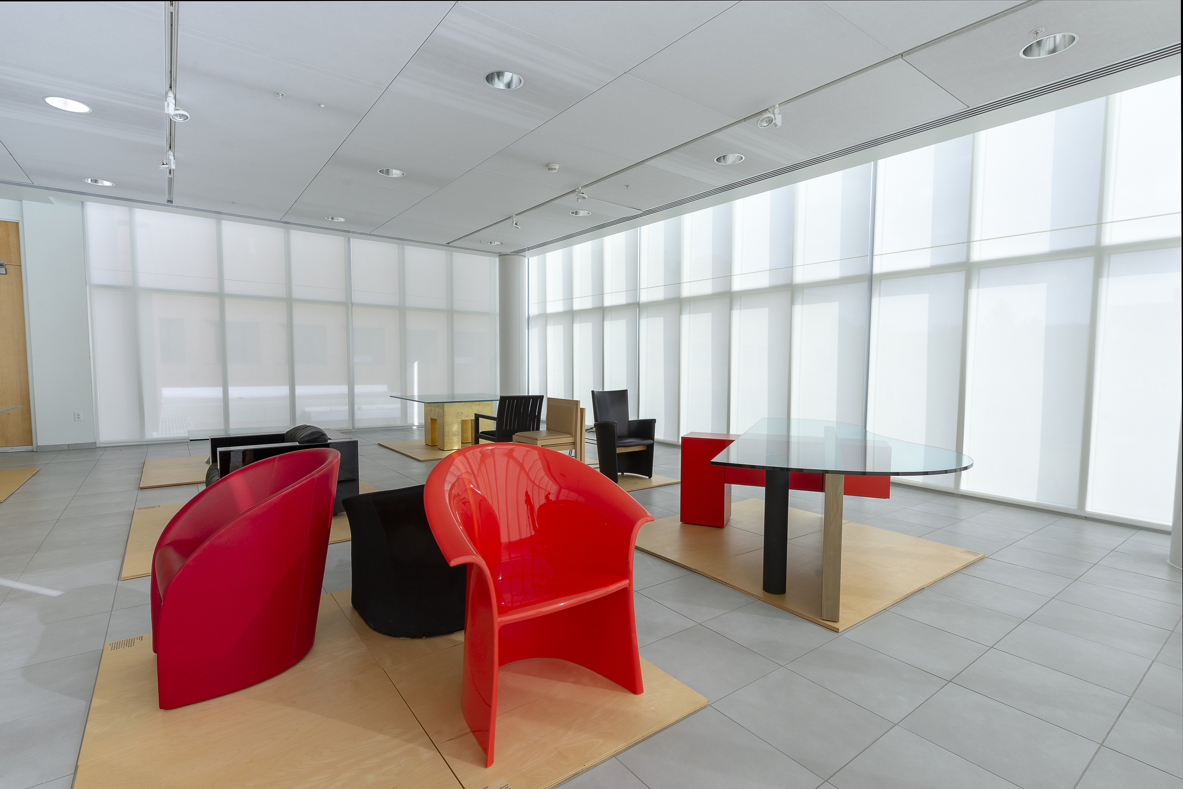 Modern room with large windows and a selection of contemporary chairs and tables on display.
