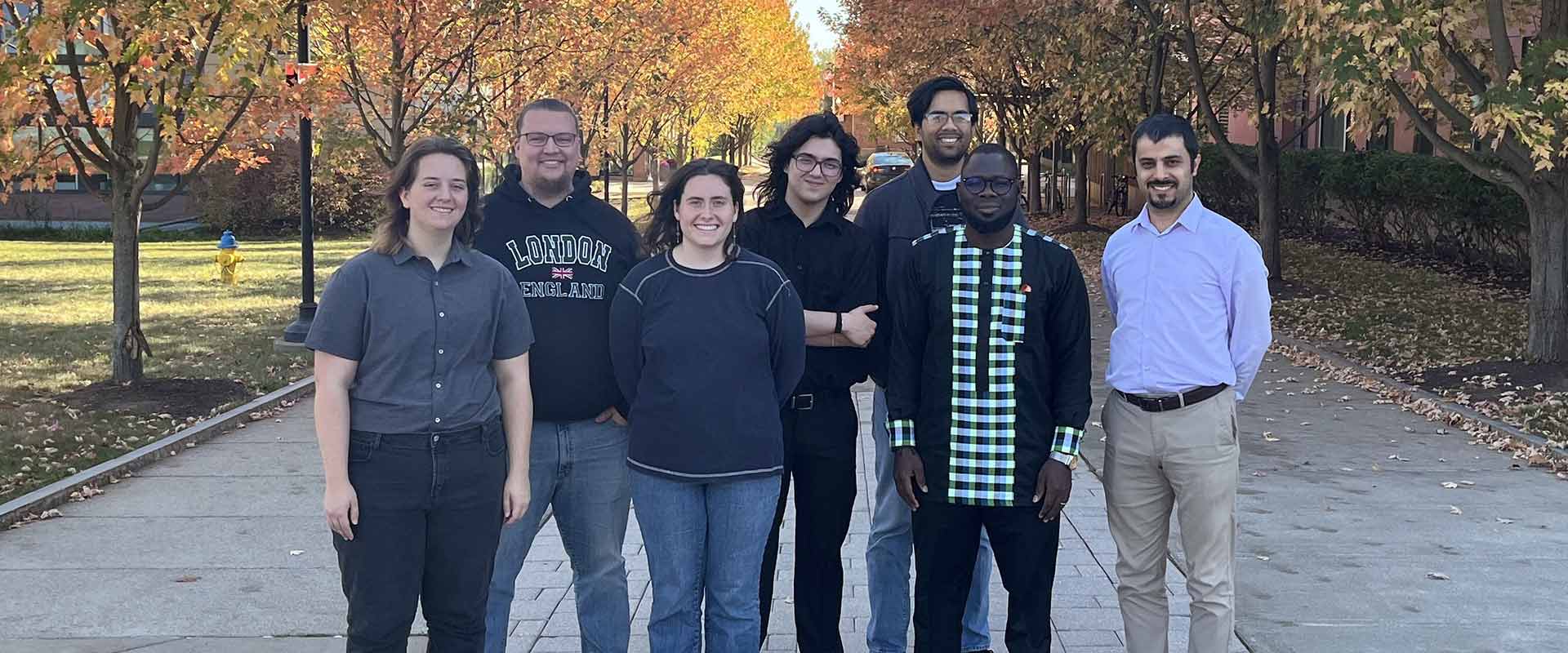 a group of people poses for a photo outdoors.
