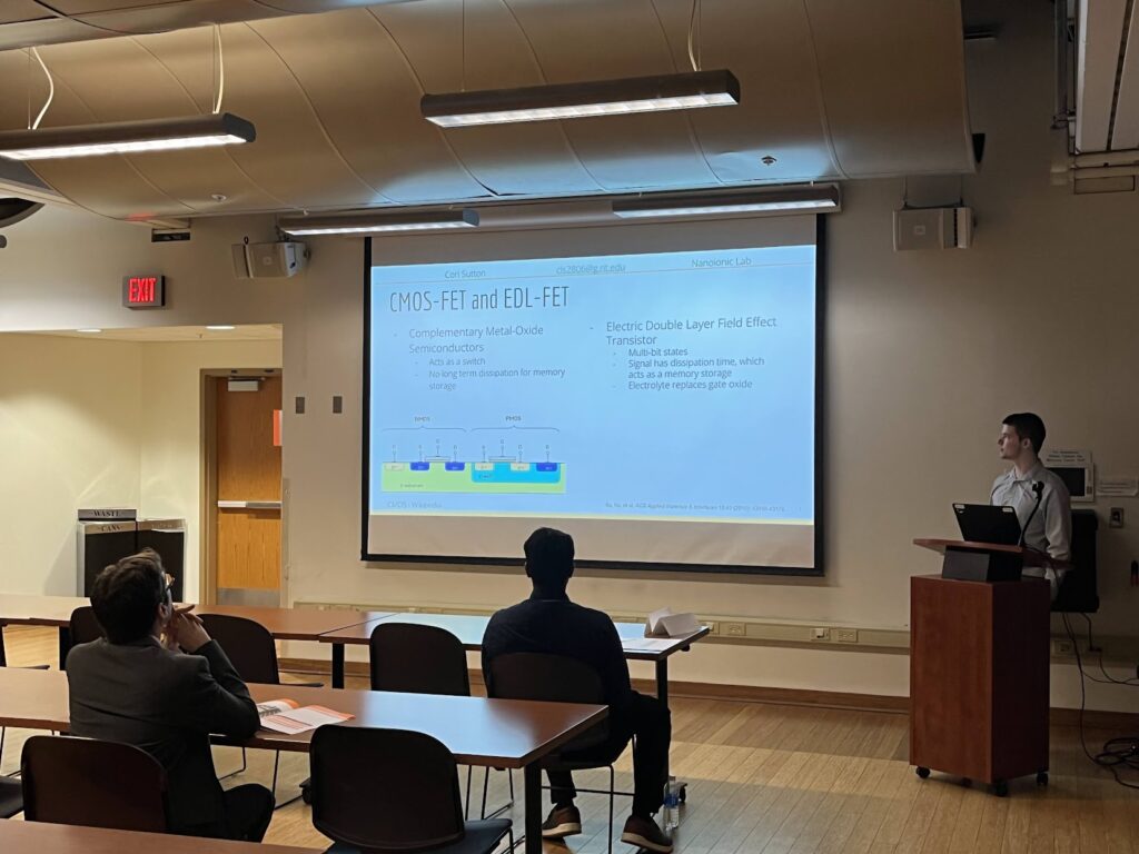 Cori presenting research to an audience at the 2023 RIT Undergraduate Research Symposium.