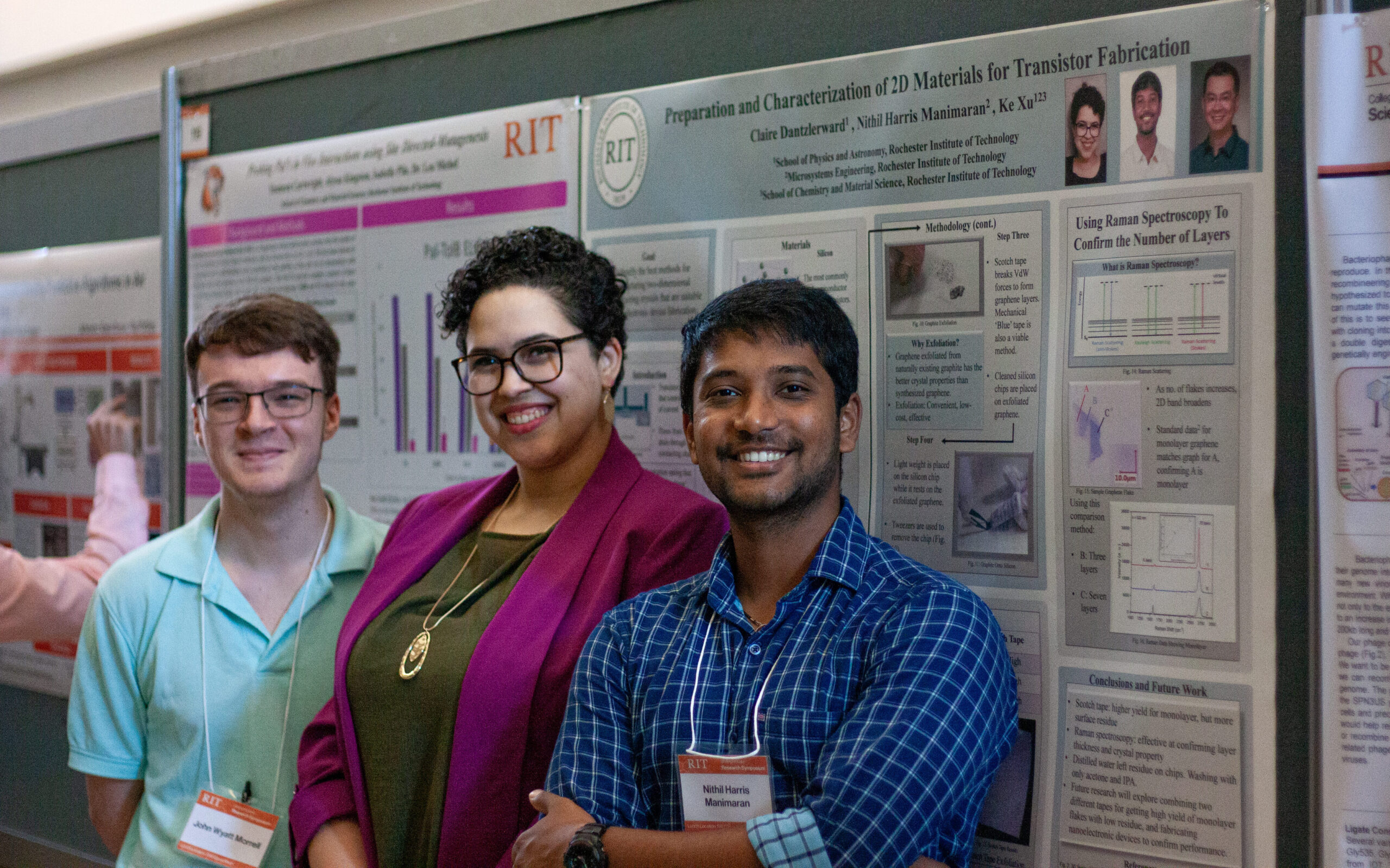 Three people wearing symposium badges stand in front of an RIT research poster about preparation and characterization of 2D materials for transistor fabrication. Other research posters are visible beside and behind the group.