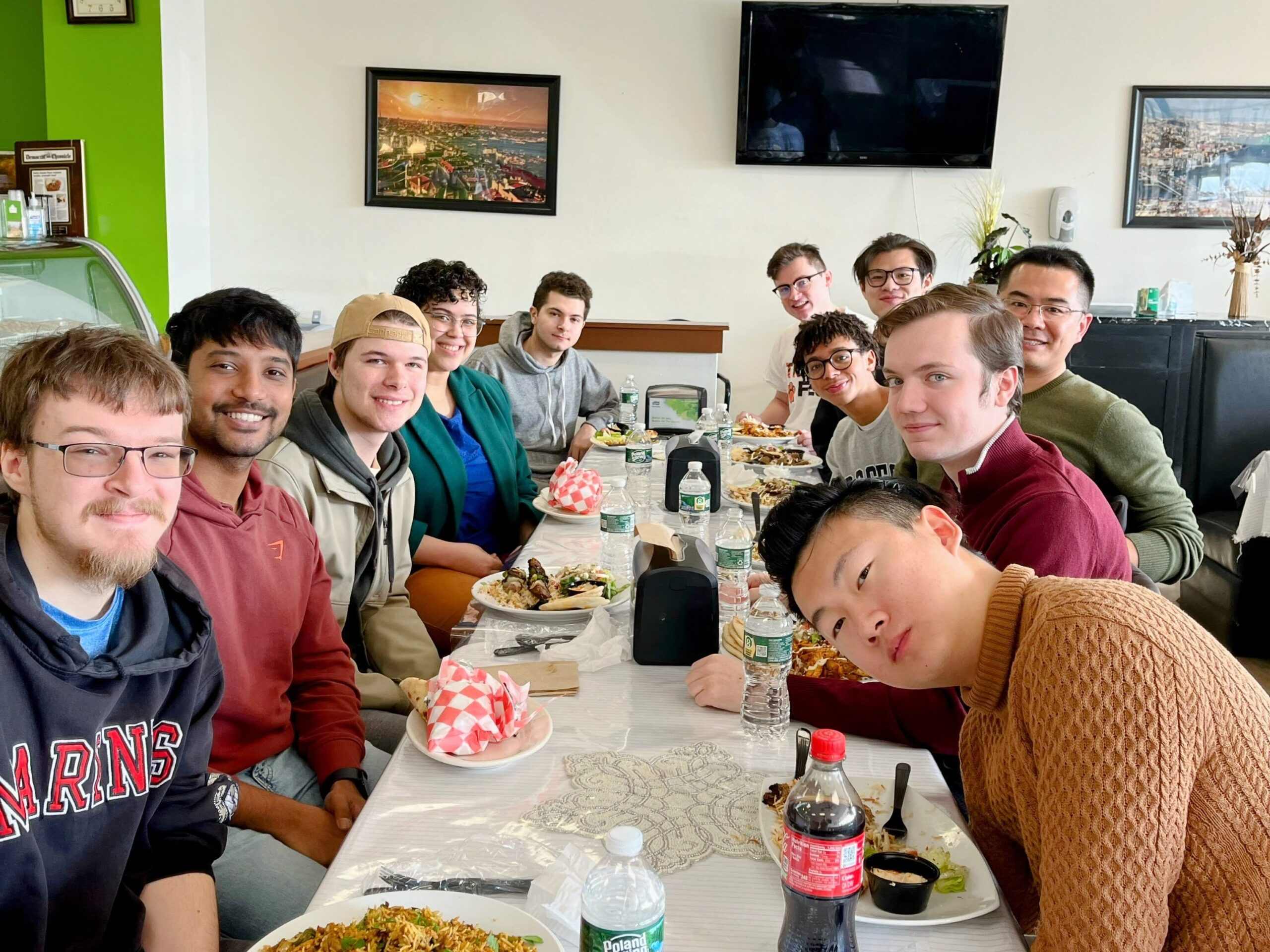 Xu Group members seated at a restaurant table with Mediterranean food.
