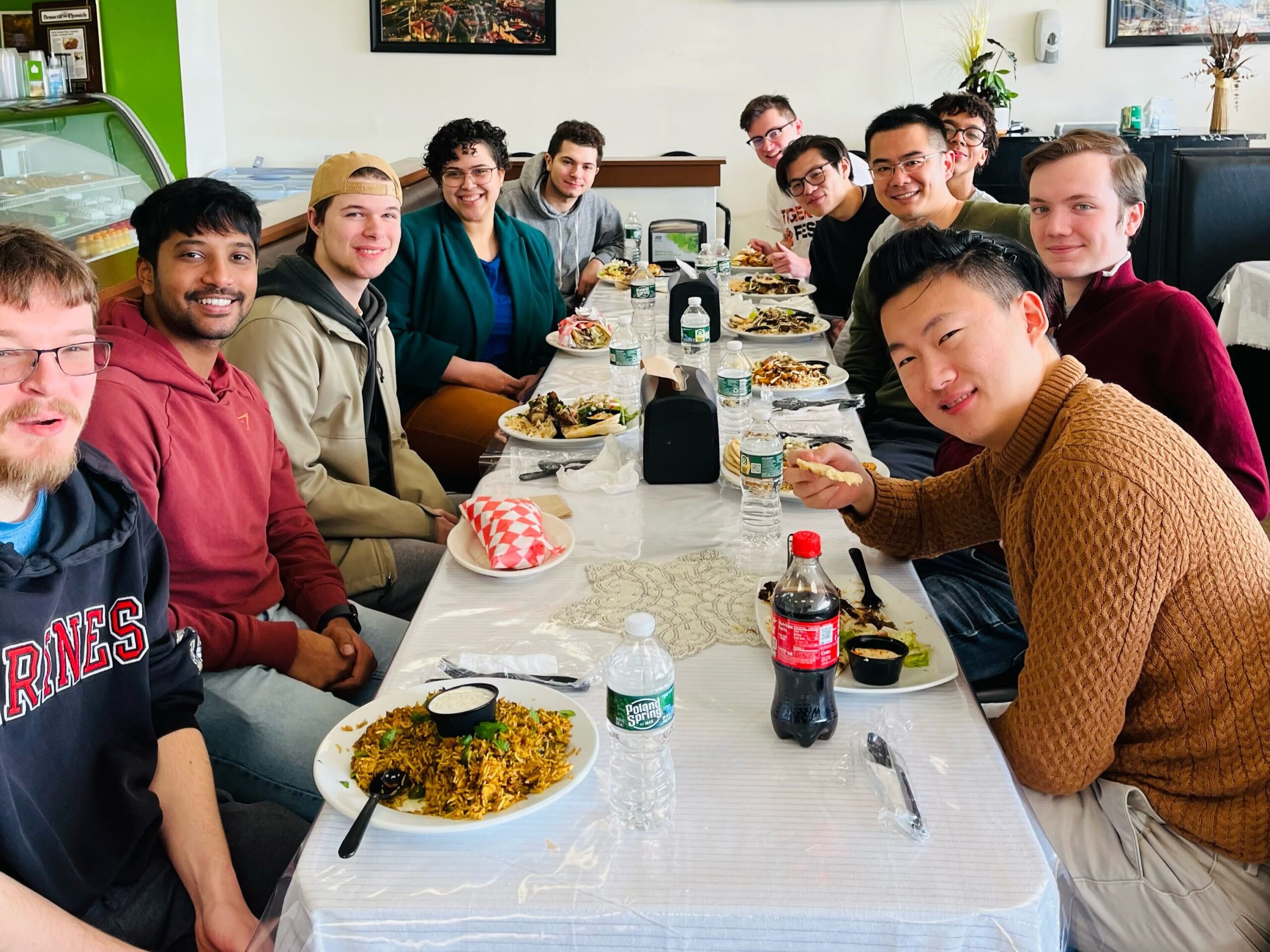 Xu Group members seated at a restaurant table with Mediterranean food.