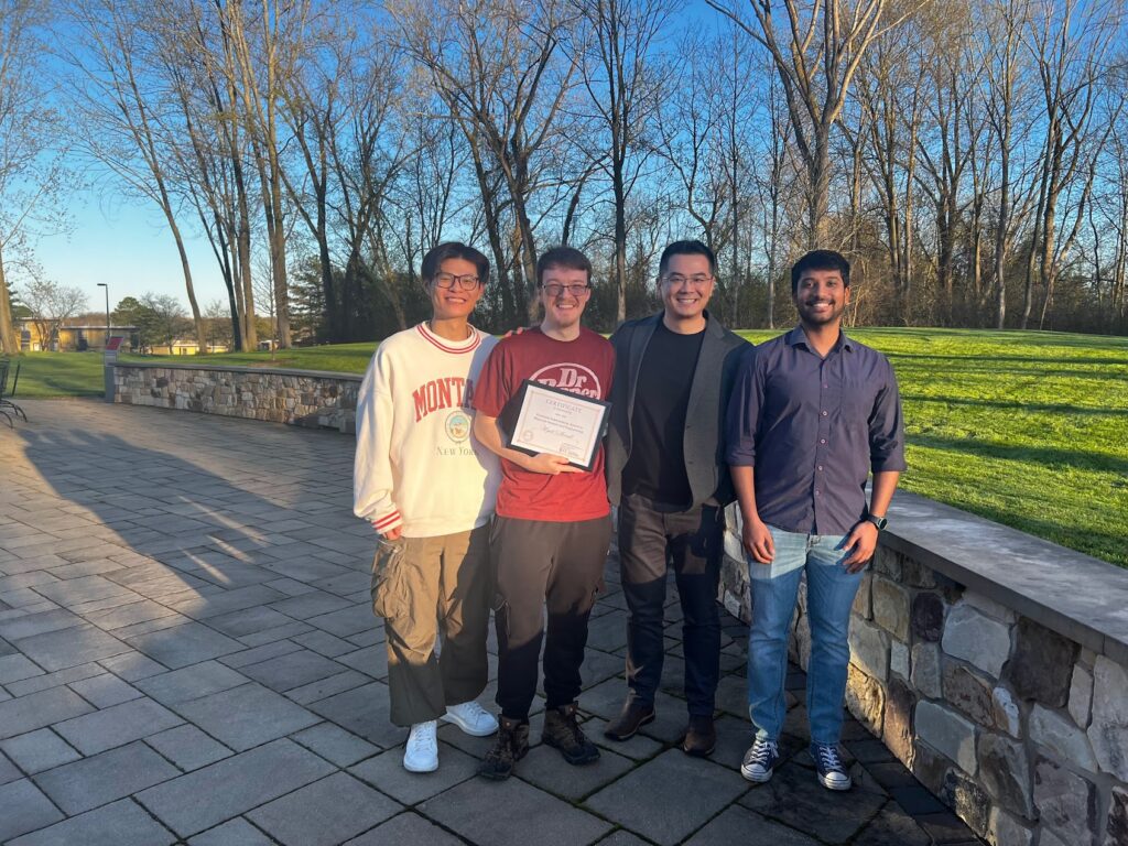 Students standing outside with an award certificate after an achievement event.