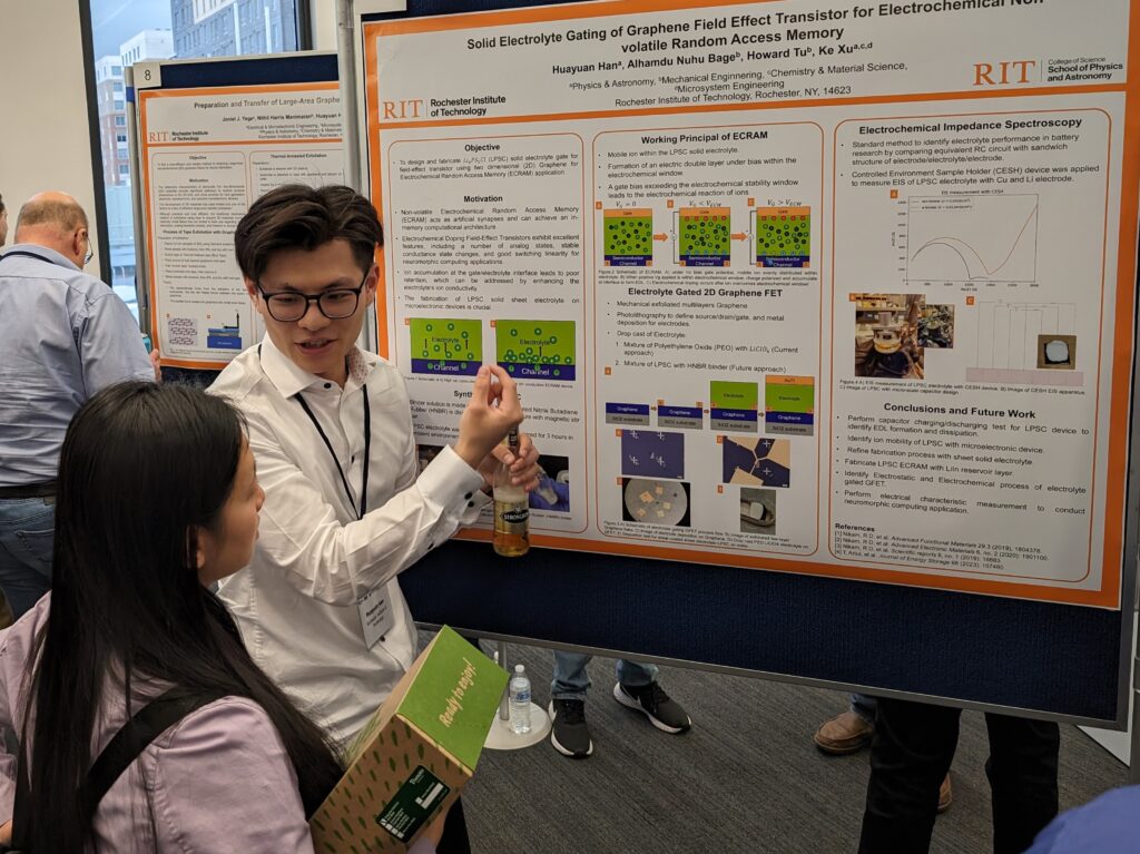 A student explaining a semiconductor research poster to an attendee at a poster session.