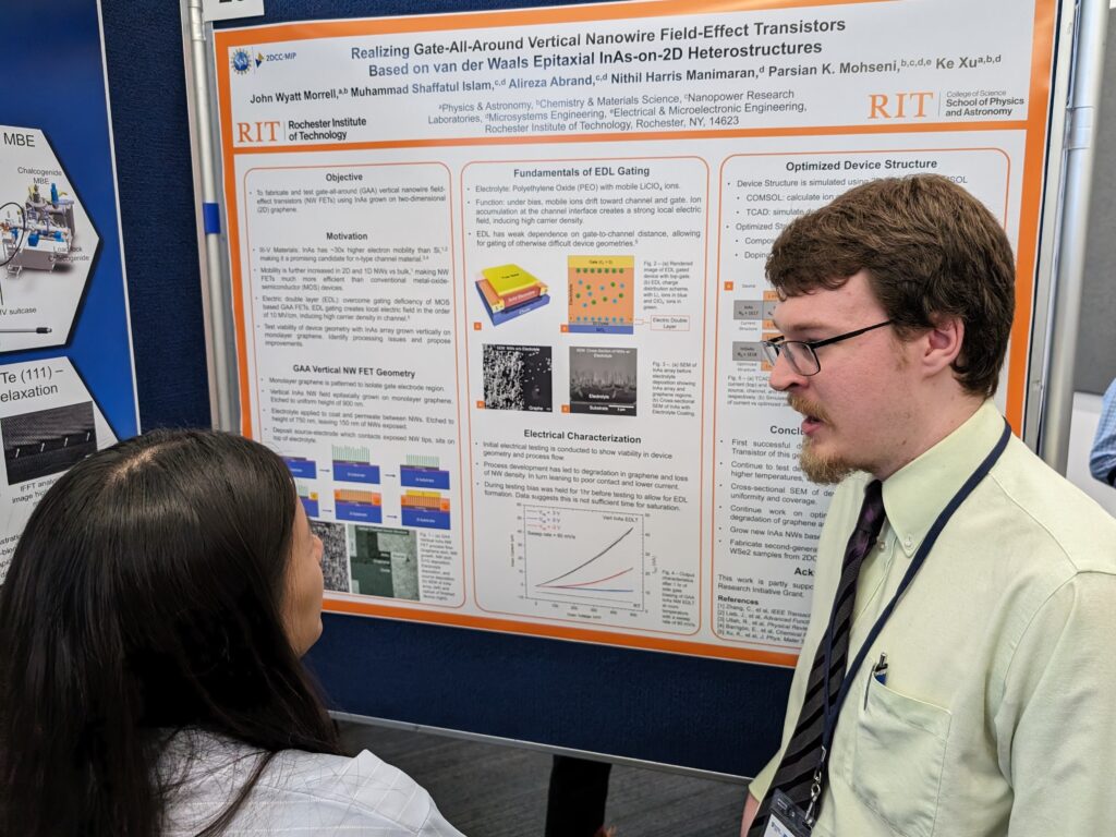A student presenting a poster about ionically gated transistors with an attendee listening.