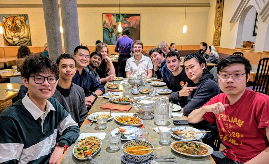 Xu Group members gathered around a restaurant table celebrating the end of 2024.