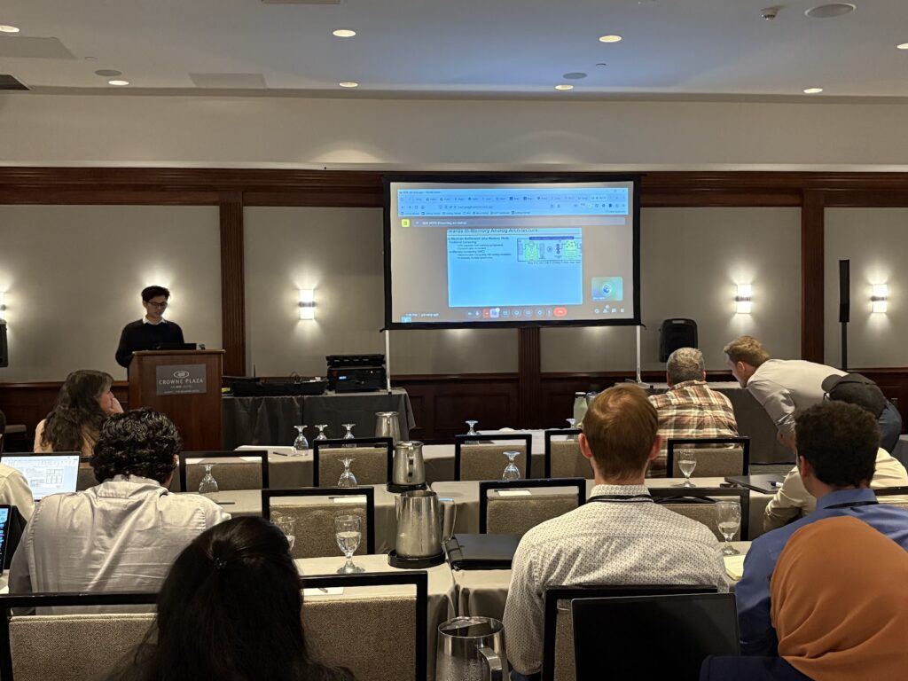 Han presenting a technical talk to an audience in a conference room.