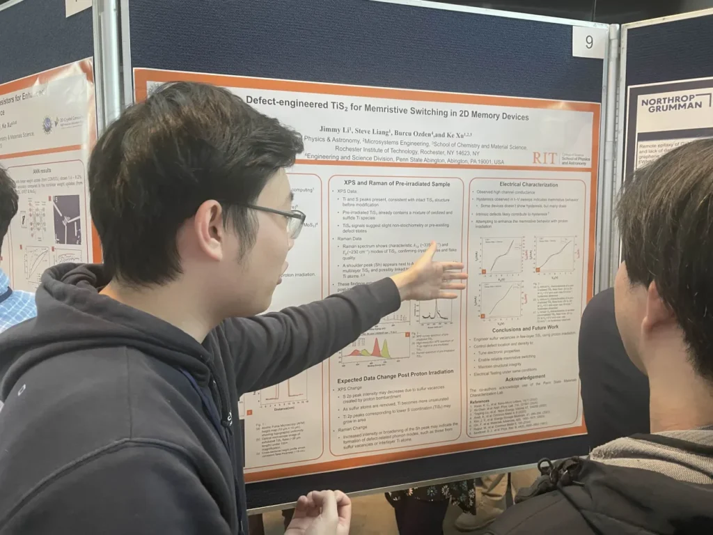 Jimmy pointing to graphs on a research poster while discussing his work with attendees.