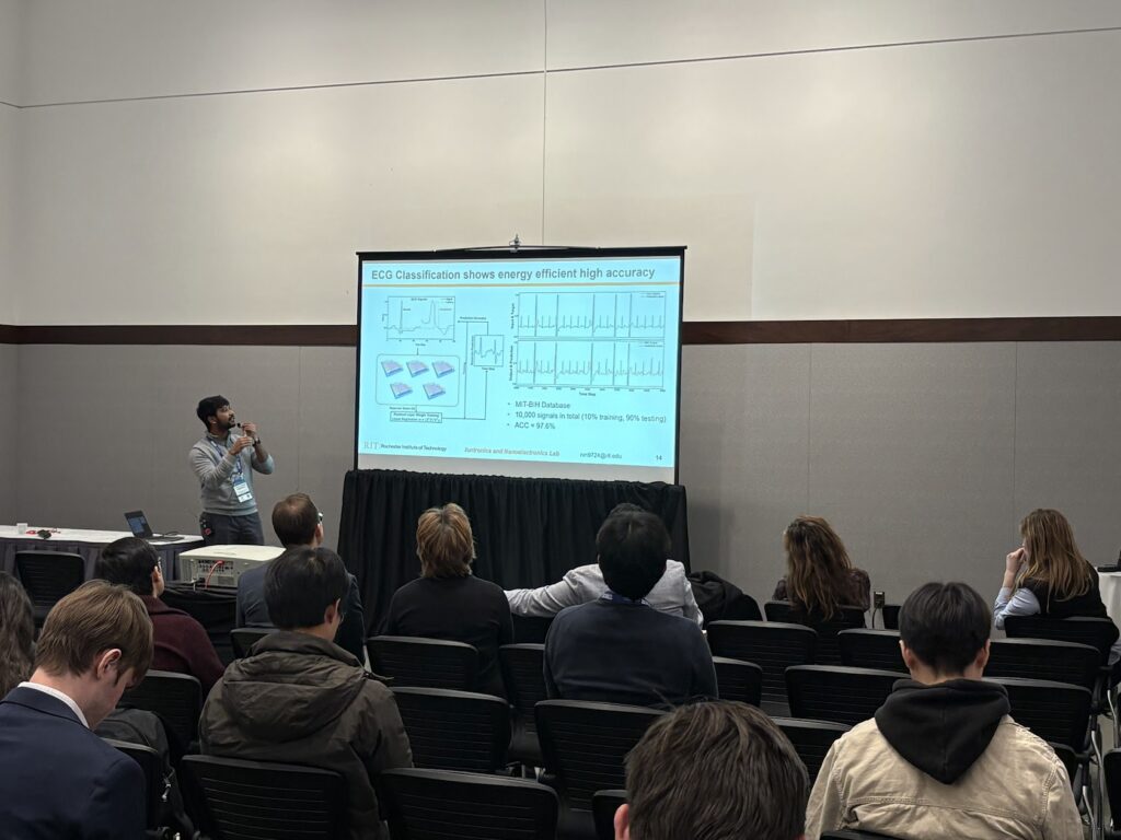 Nithil presenting a technical slide to an audience in a conference room.