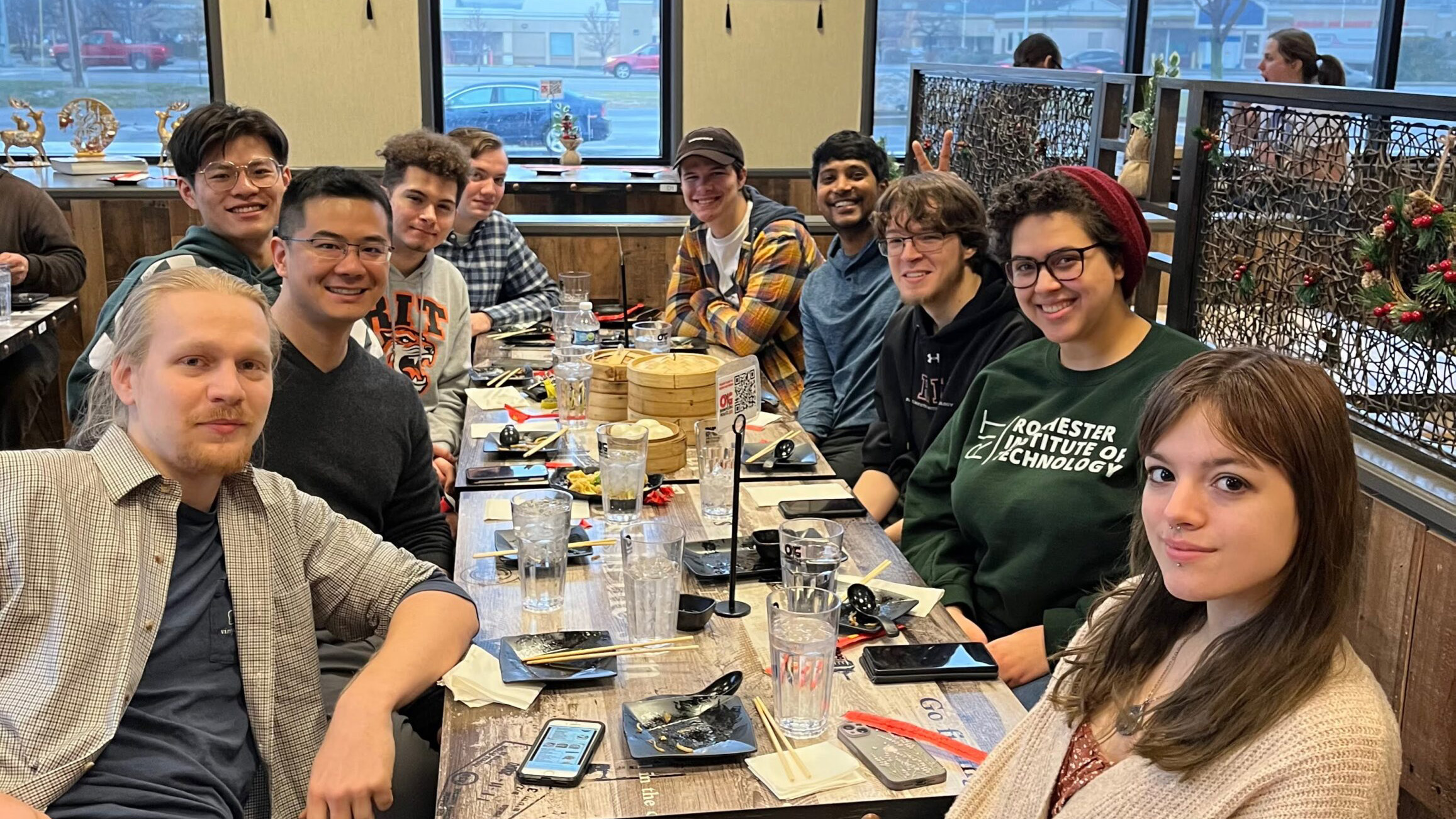 Xu Group members seated together around a restaurant table during a group outing.
