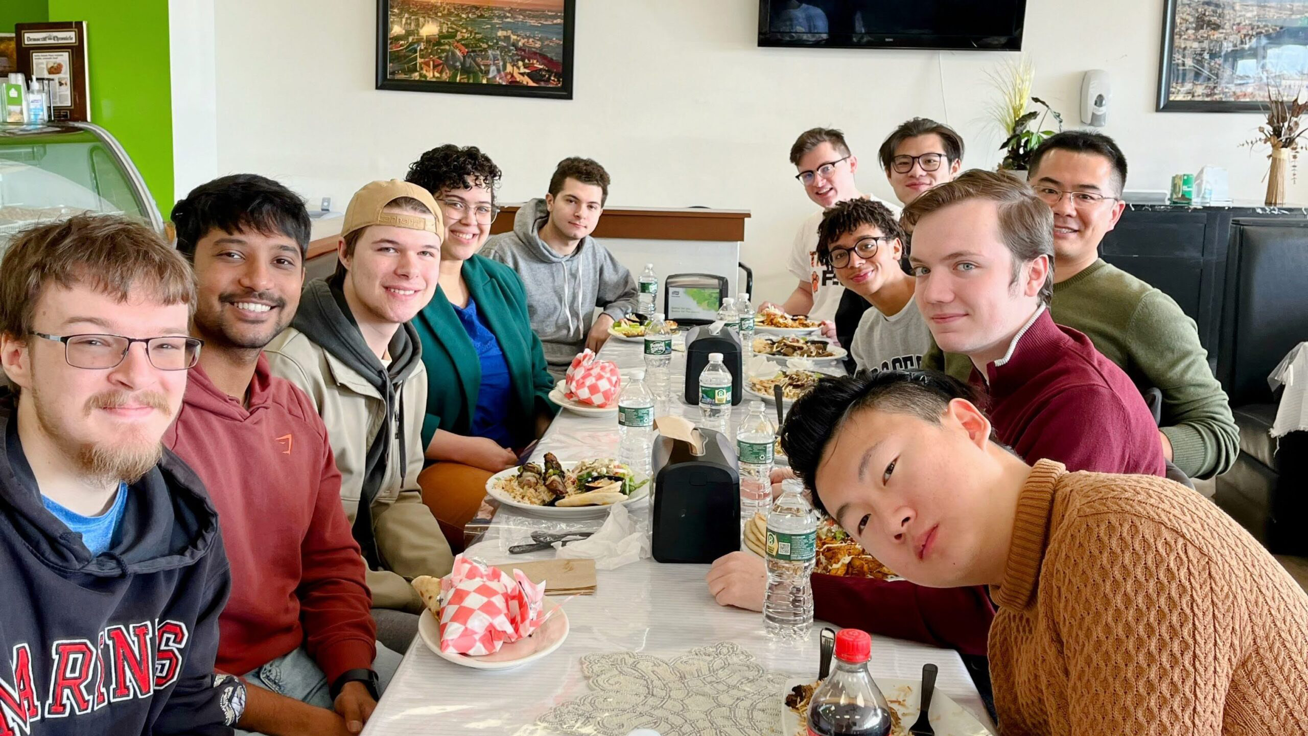 Xu Group members seated together at a restaurant table during a group meal.
